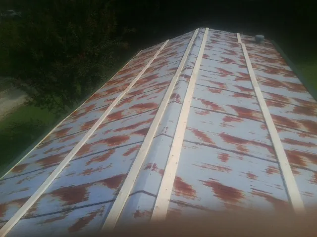 Rusted metal roof panels with new wood purlins before replacement — Storm Damage Roof Repair in Moffit by Roofing Brothers