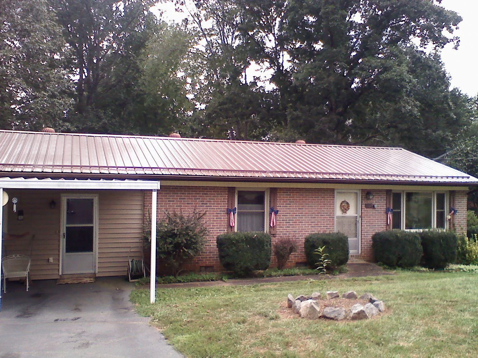 Bronze metal roof and carport on a brick ranch home — Roof Repair work by our crew in Moffit